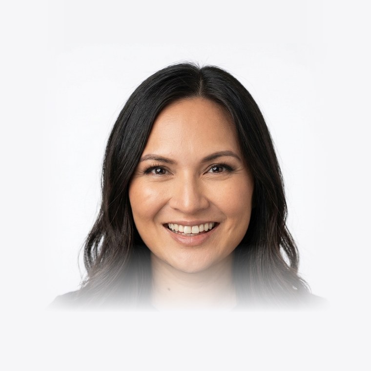Headshot of Monique Parungao, smiling, with long dark wavy hair and a black top